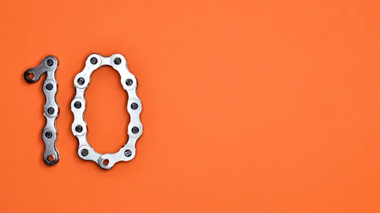 Number ten formed from a silver bike chain on an orange background, representing the Ten Essential Lending Tools to transform your business in 2025.