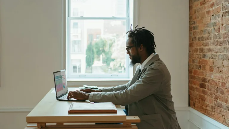 a person sitting at a desk with a laptop and papers
