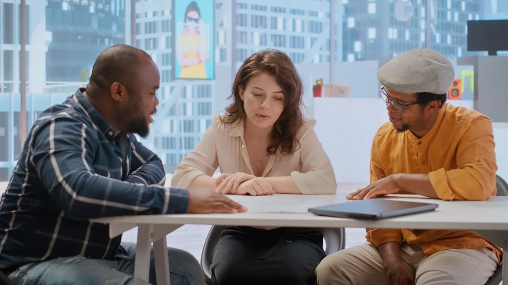 Three colleagues discussing lending technology questions and answers at the conference table