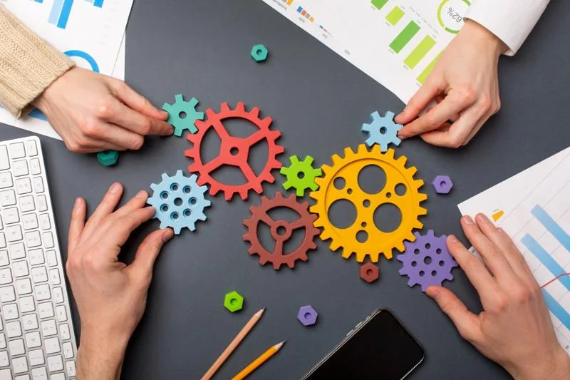 Hands assembling colorful gears symbolizing automation and workflows.