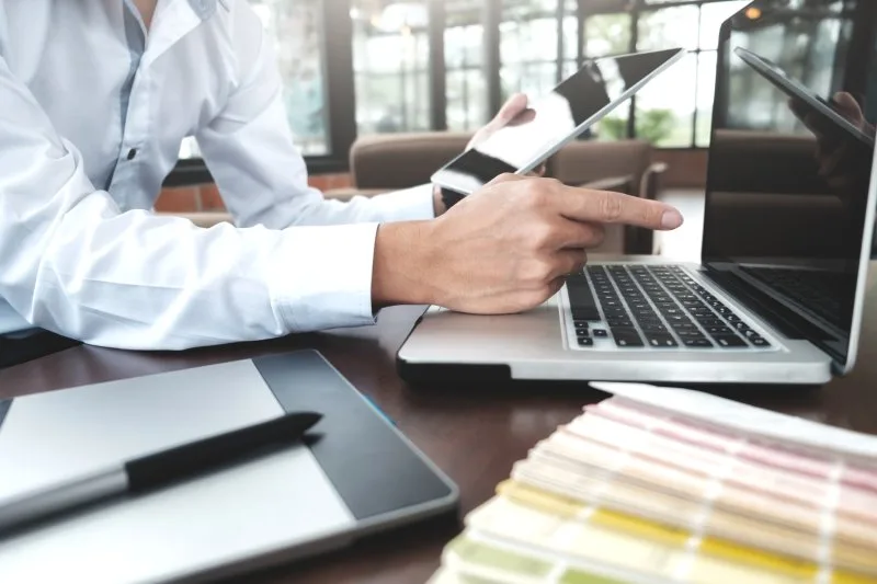 Business professional comparing loan management software platforms on laptop for lending operations