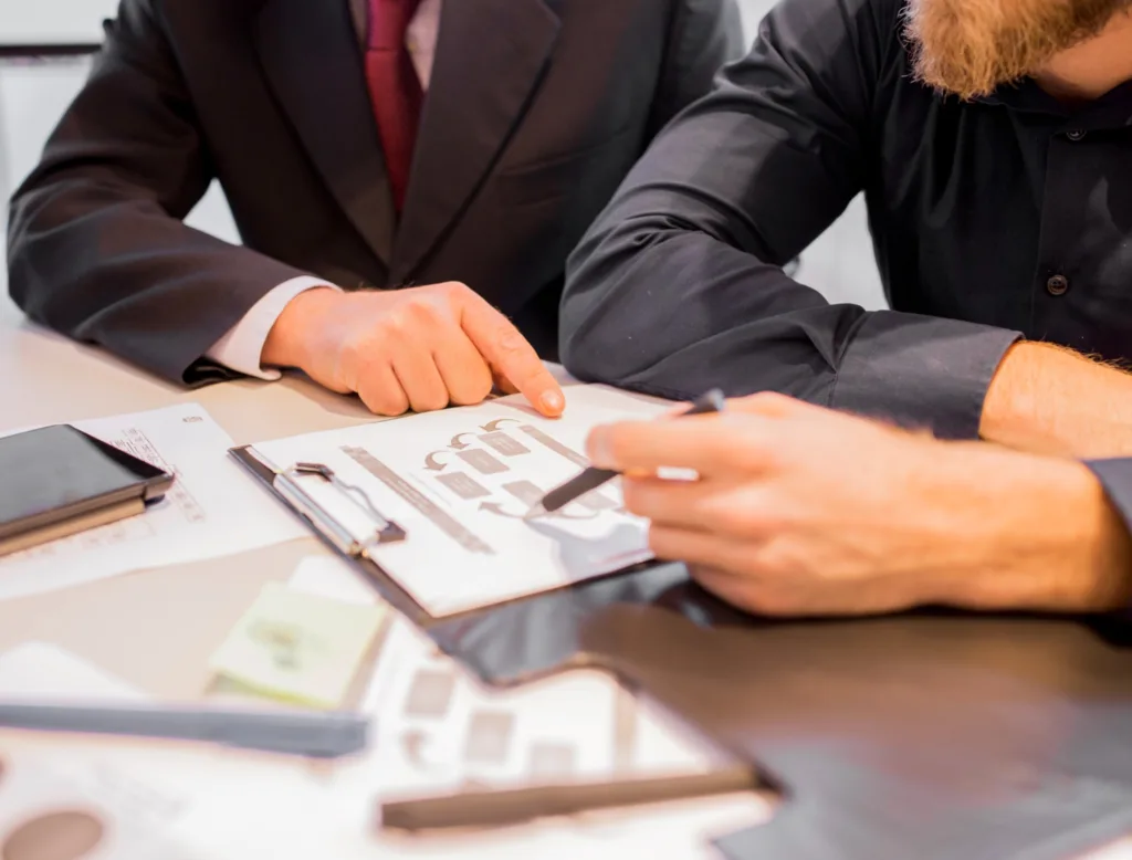 Two professionals reviewing complex loan structures and repayment flow diagrams