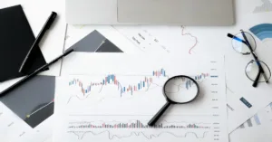 Magnifying glass over financial chart showing credit performance data and trends.