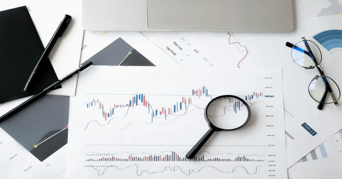 Magnifying glass over financial chart showing credit performance data and trends.