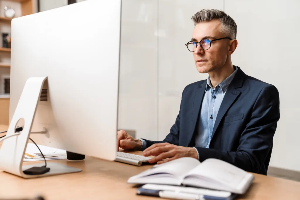 Loan servicer reviewing reverse mortgage statement details on a desktop computer.