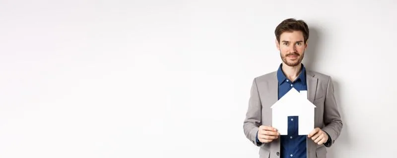 Man holding a paper house to illustrate hard money lending
