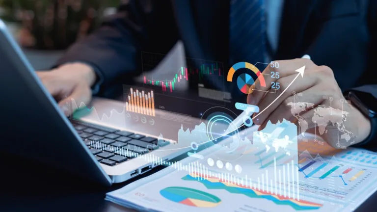 Business professional analyzing financial data on a laptop, with digital charts, graphs, and global analytics visuals overlaid.