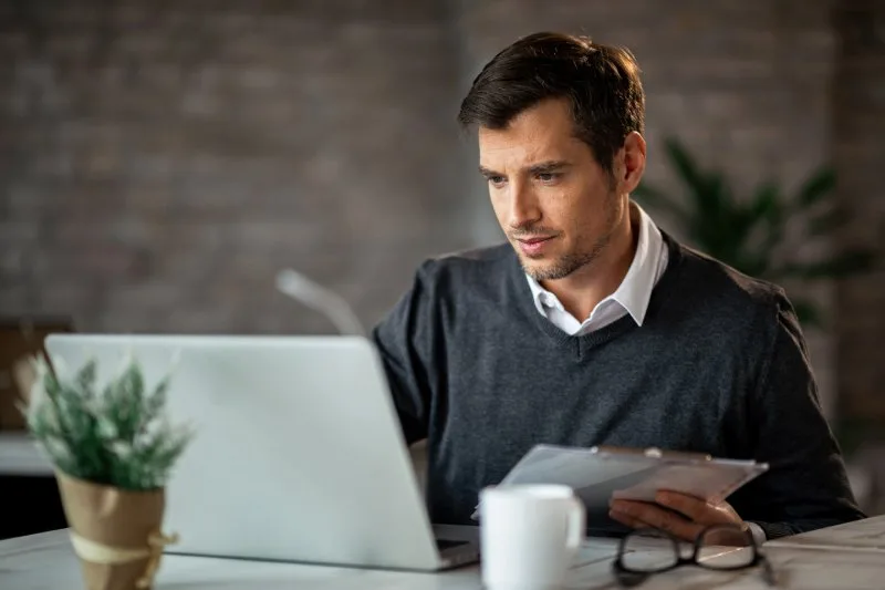  Loan servicer reviewing loan management software options at his desk