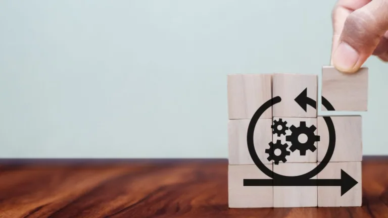 Wooden blocks showing circular workflow with gears representing the loan lifecycle process from origination through servicing