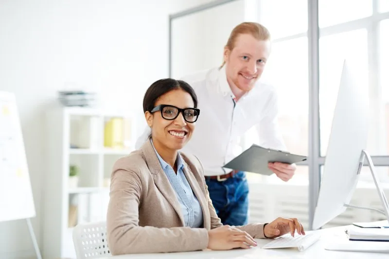 Lending professionals analyzing loan portfolio data and reporting tools on desktop computer