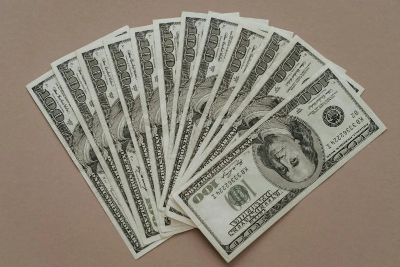 Stack of hundred dollar bills representing payday loan amounts ranging from $100 to $1,500