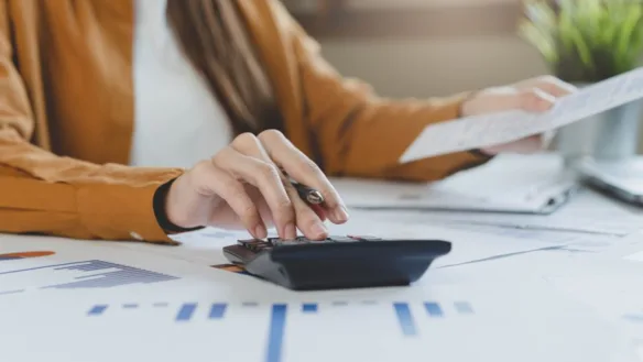 Close-up of the hand of a loan servicer calculating payday loan terms