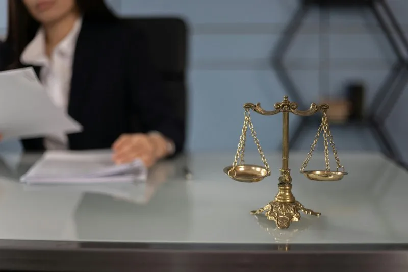 Scales of justice on a legal desk, illustrating repossession laws by state and borrower protections requirements.