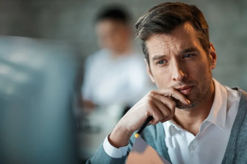 Loan servicer evaluating loan management software strengths and considerations at office desk 